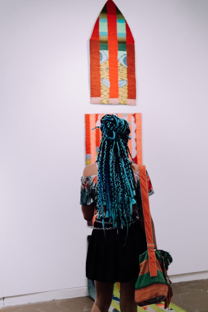 A visitor to Deli Gallery's booth at the MECA art fair in San Juan. Photo courtesy Discover Puerto Rico.