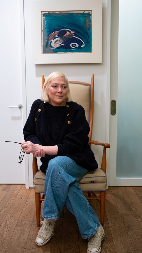 Gina Nanni sitting underneath a Basquiat (“Untitled—Car”). Courtesy Gina Nanni.