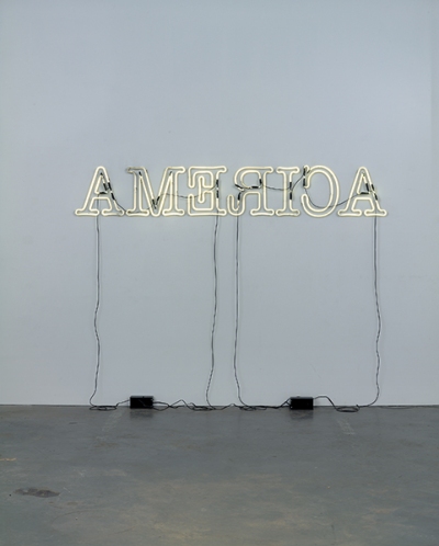 A neon sign spelling America but all the letters are written backwards