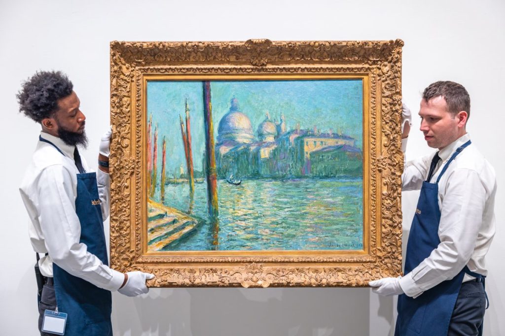 Two art handlers holding painting