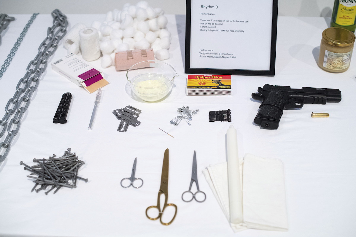 A display case with various objects, including pairs of scissors and a gun.