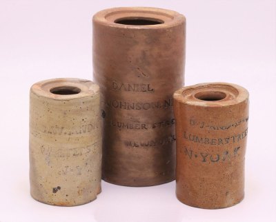 Grouping of three ceramic jars of various sizes and shades that show the names of different Black oysterman based in New York. 